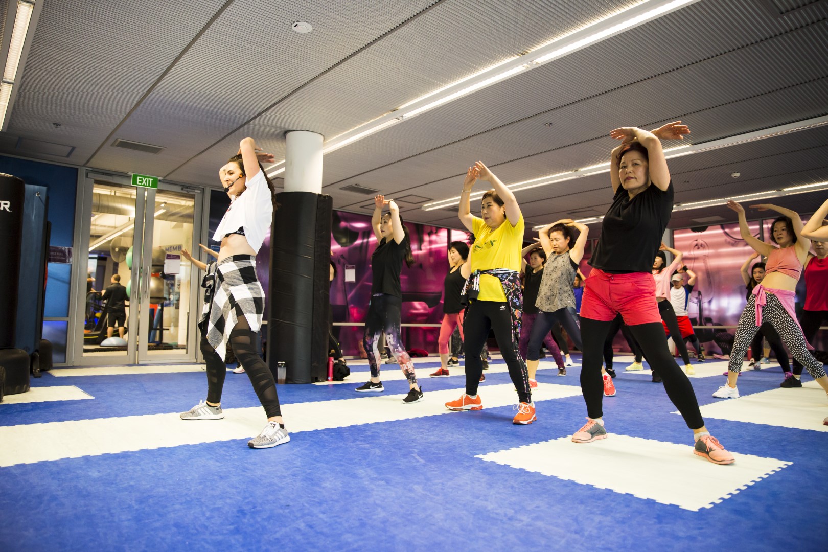 Zumba class performing a dance move where their hands are above their heads