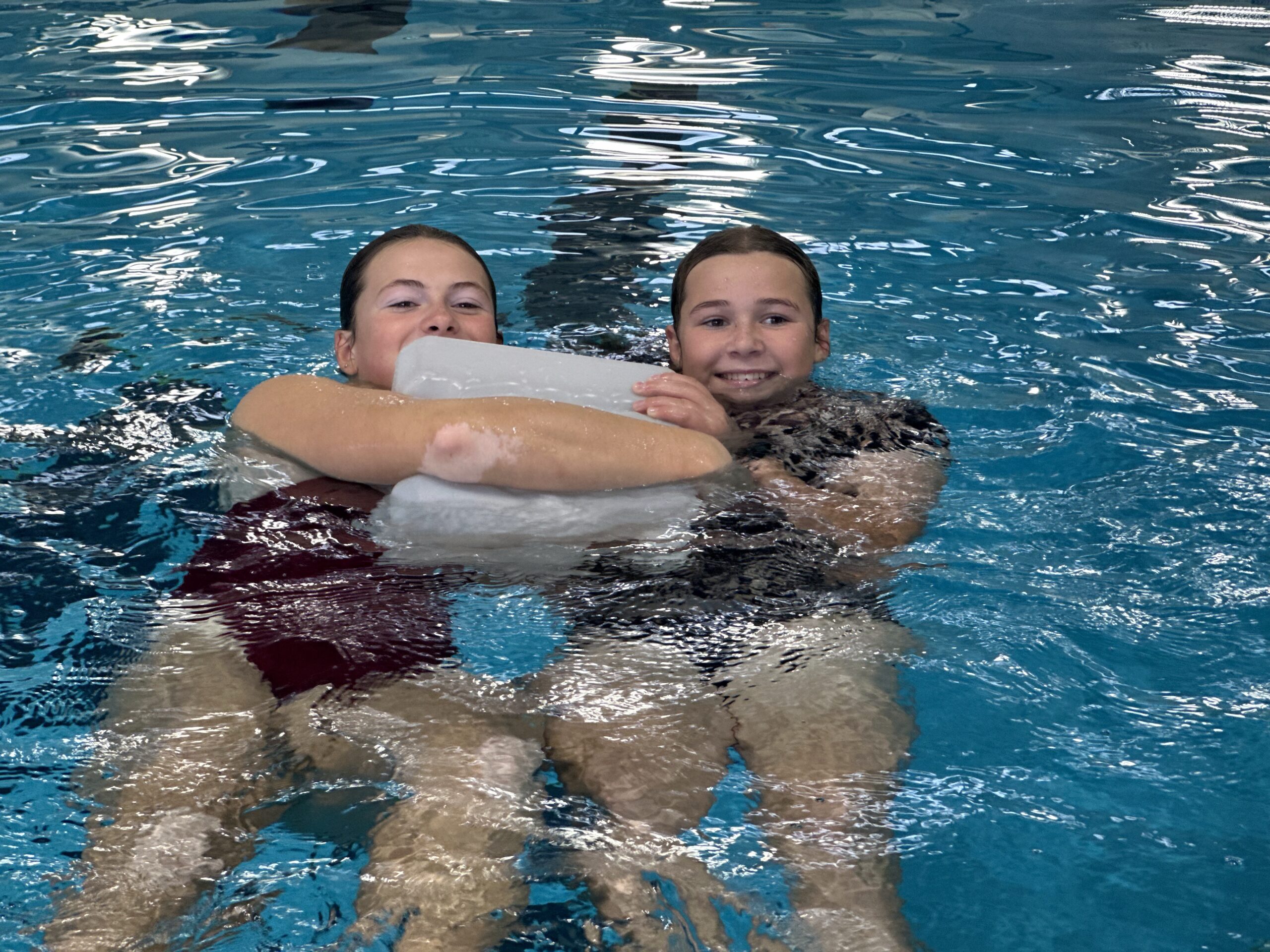 Surf Safety two girls holding a floating device