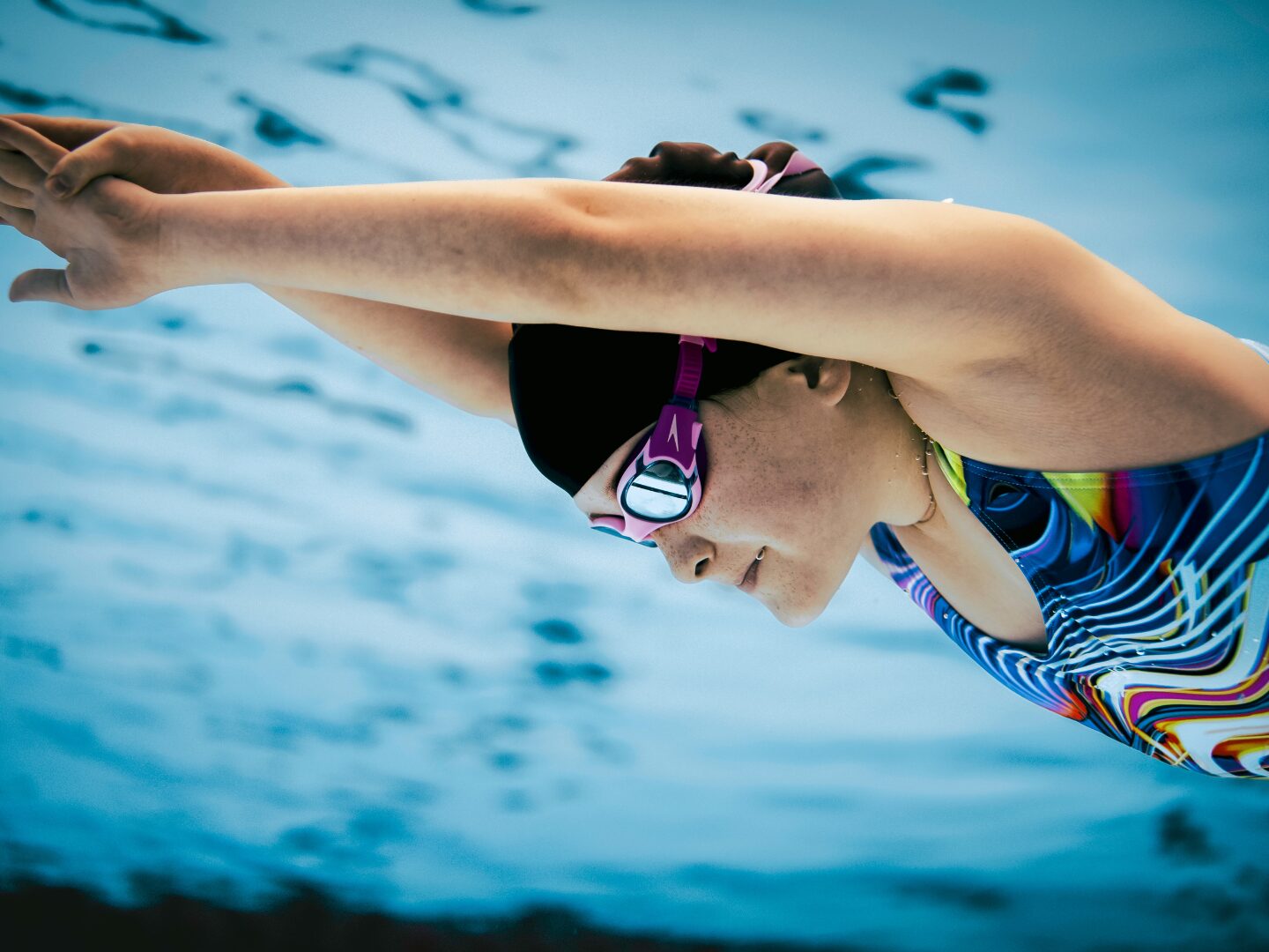 girl swimming in streamline underwater wearing Speedo swimwear