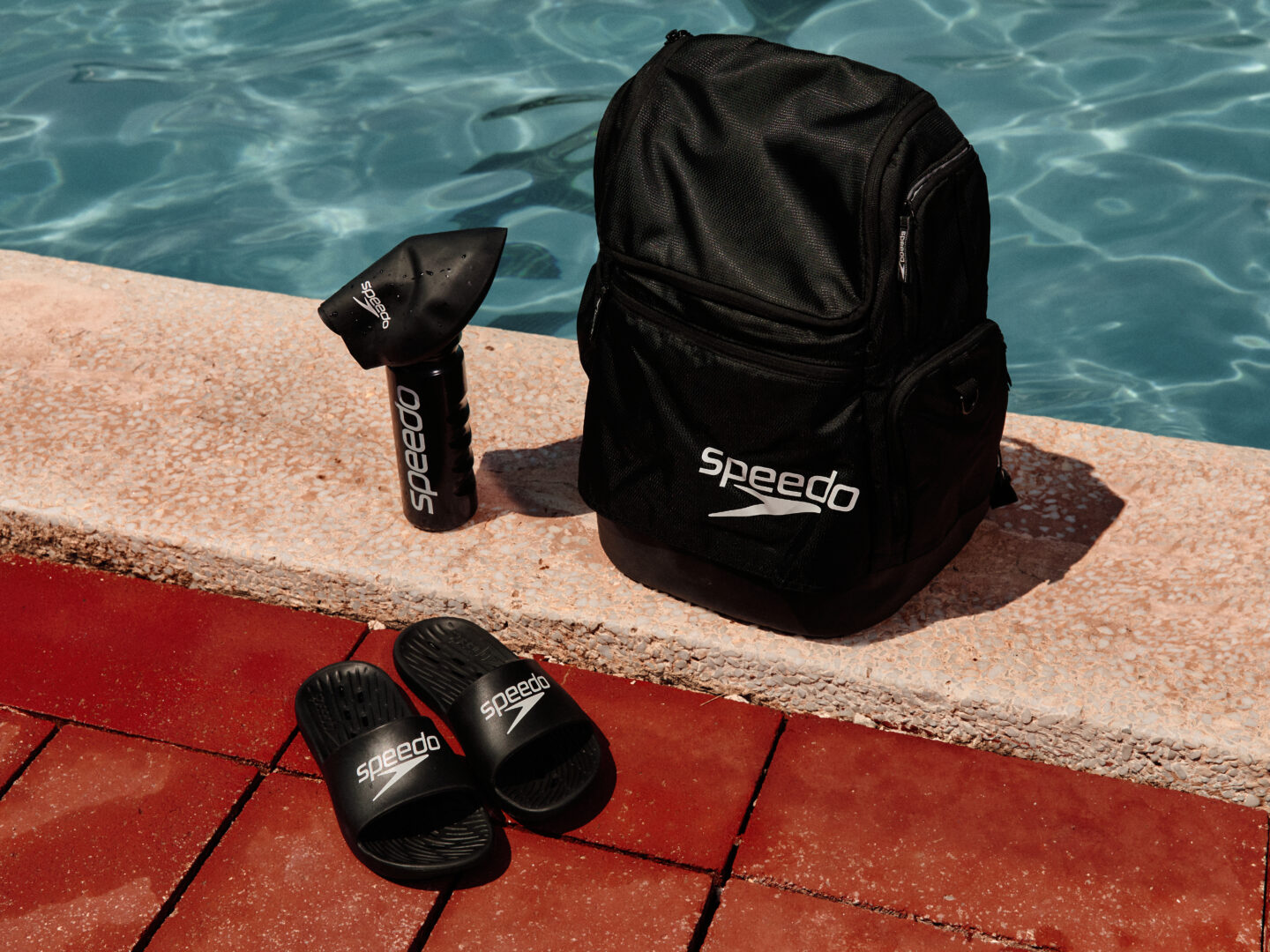 Speedo gear and equipment on the side of a pool