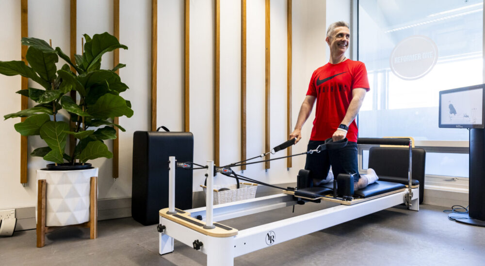 Man on reformer pilates machine