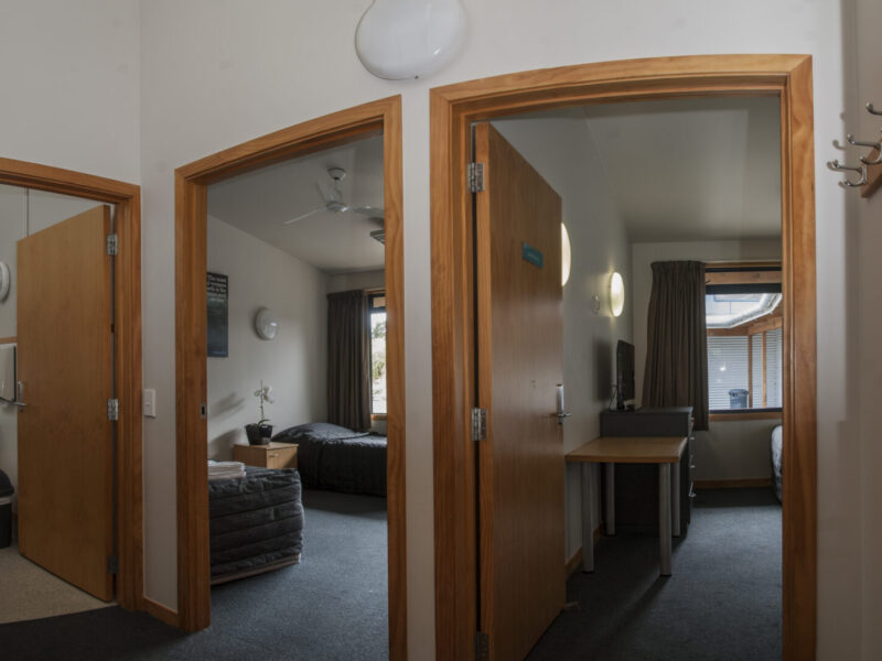 Two AUT Millennium Accommodation rooms and a bathroom, photo taken from the hallway