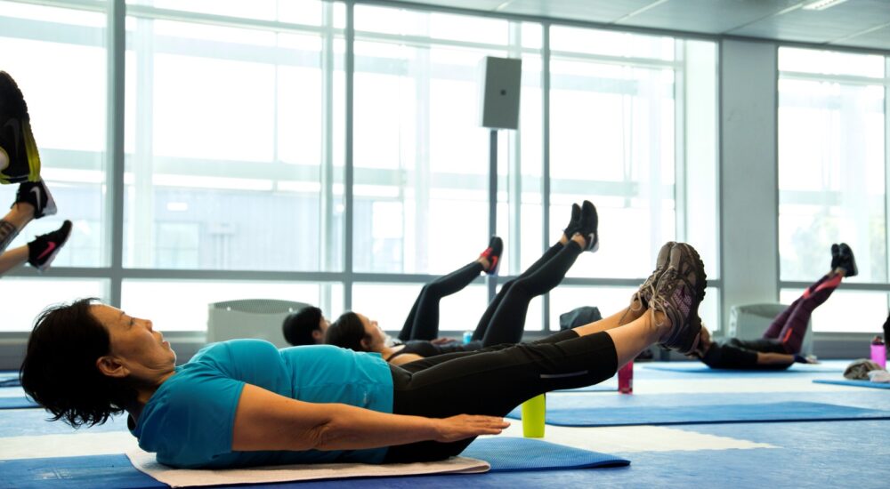 Gym Members in a core class with their legs elevated