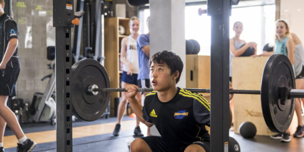 Athlete Development athlete in a squat with a barbell