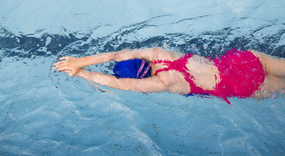 Swimmer gliding through water in a streamline position.
