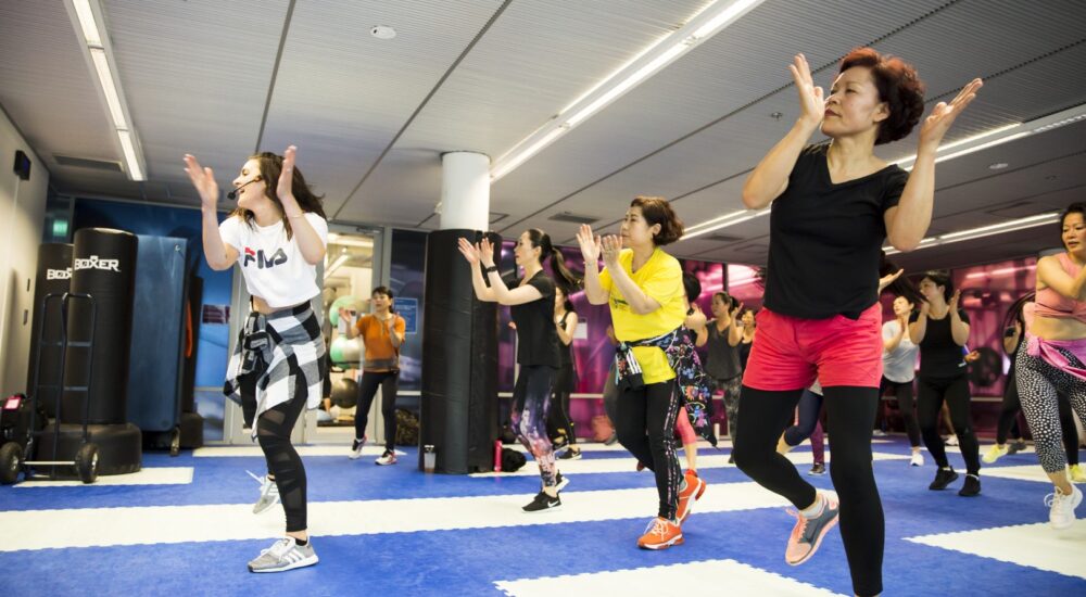 Zumba class clapping from side to side as part of a dance