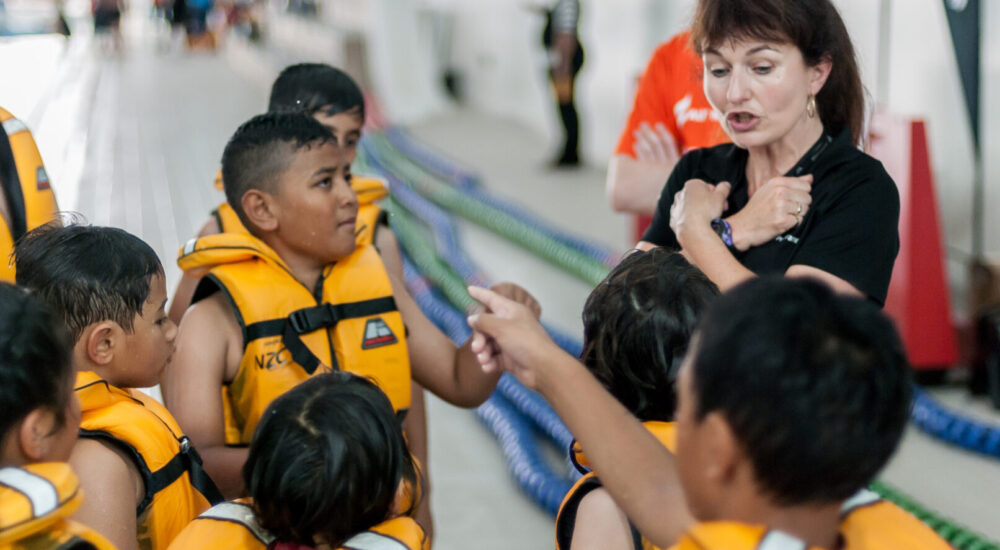 Schools Programme Instructor gives children wearing life jackets instructions